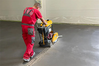 Ein Arbeiter schneidet Beton mit einer Betonschneidemaschine